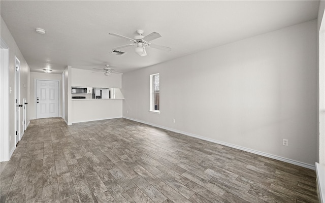 unfurnished living room featuring hardwood / wood-style flooring and ceiling fan