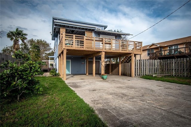 938 E Lakeside Dr, Corpus Christi, TX 78418 - rear view of property with a carport, driveway, and a wooden deck