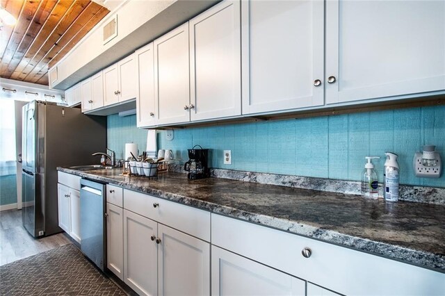938 E Lakeside Dr, Corpus Christi, TX 78418 - kitchen featuring stainless steel appliances, wood ceiling, a sink, light wood-type flooring, and white cabinetry