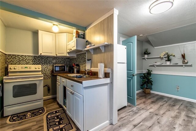 938 E Lakeside Dr, Corpus Christi, TX 78418 - kitchen with white appliances, a sink, light wood finished floors, dark countertops, and tasteful backsplash