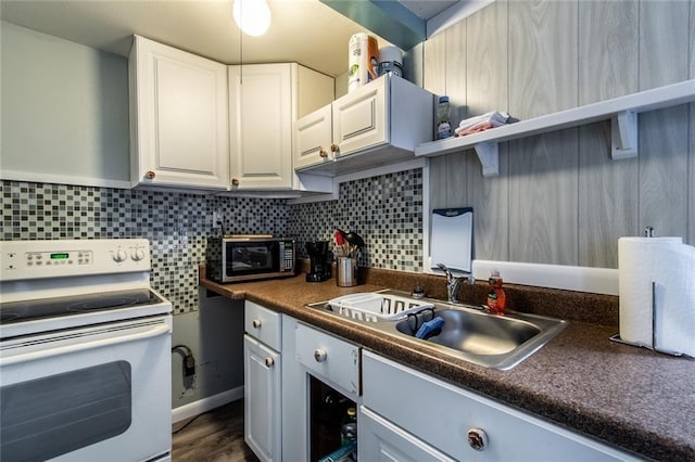 938 E Lakeside Dr, Corpus Christi, TX 78418 - kitchen featuring white range with electric stovetop, stainless steel microwave, dark countertops, white cabinetry, and tasteful backsplash