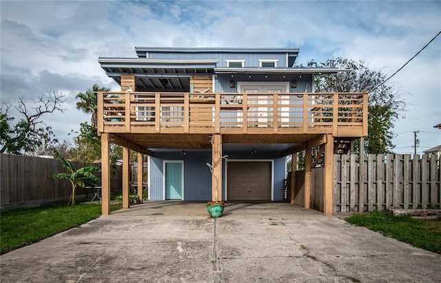 938 E Lakeside Dr, Corpus Christi, TX 78418 - view of front of property featuring a carport, concrete driveway, a wooden deck, and an attached garage