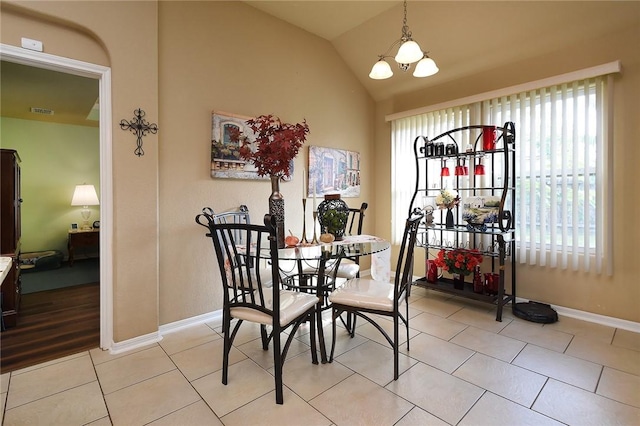 dining room featuring lofted ceiling, light tile patterned floors, and an inviting chandelier