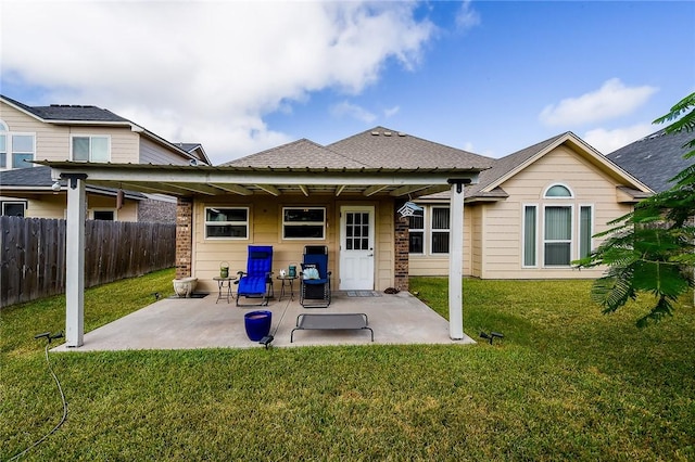 back of property with a lawn and a patio