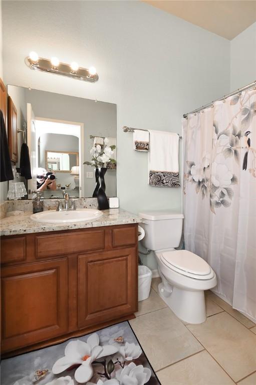 bathroom with tile patterned flooring, vanity, and toilet