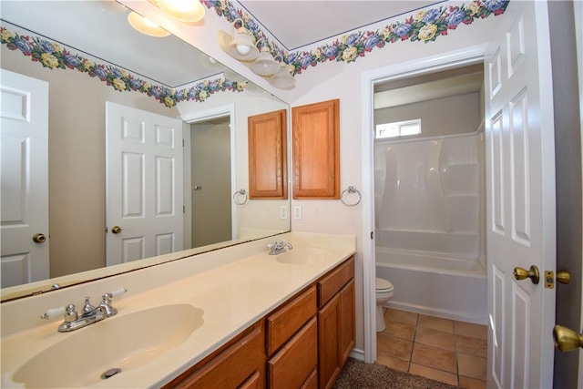 bathroom featuring double vanity, tile patterned flooring, a sink, and toilet