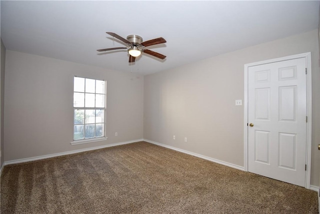 empty room with carpet, a ceiling fan, and baseboards