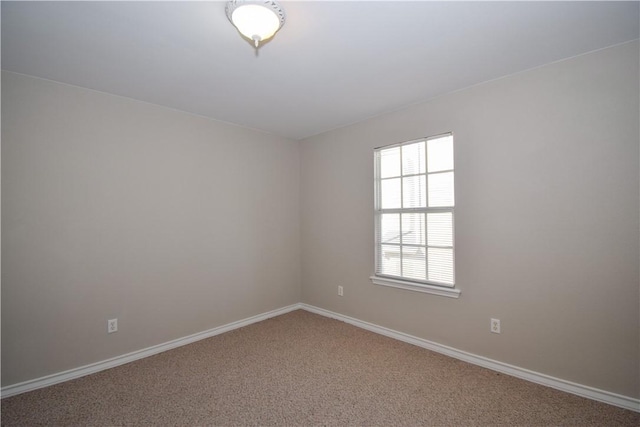 carpeted empty room featuring baseboards