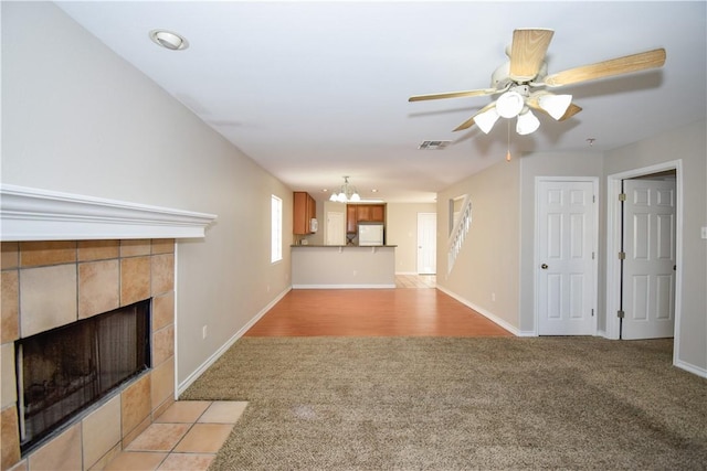 unfurnished living room featuring baseboards, light colored carpet, visible vents, and a tiled fireplace