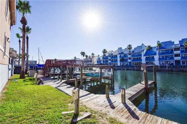 view of dock featuring a residential view, a water view, and a lawn