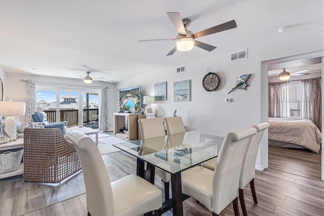 dining space with ceiling fan and light hardwood / wood-style flooring