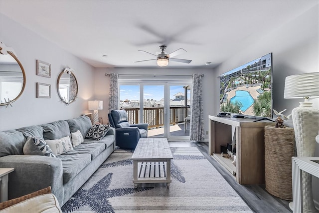 living room with dark wood-type flooring and ceiling fan