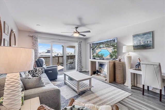 living room featuring wood-type flooring and ceiling fan