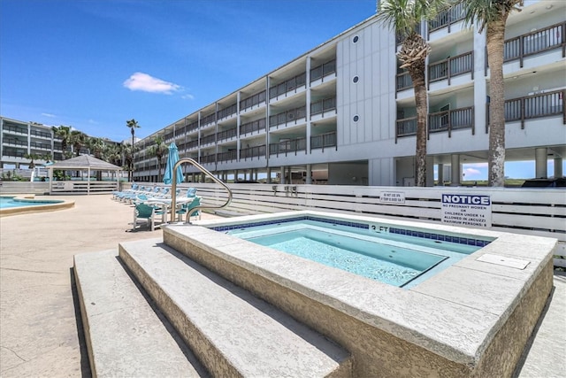 view of pool with a hot tub