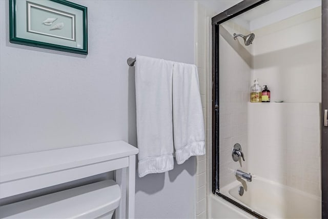 bathroom featuring bath / shower combo with glass door and toilet