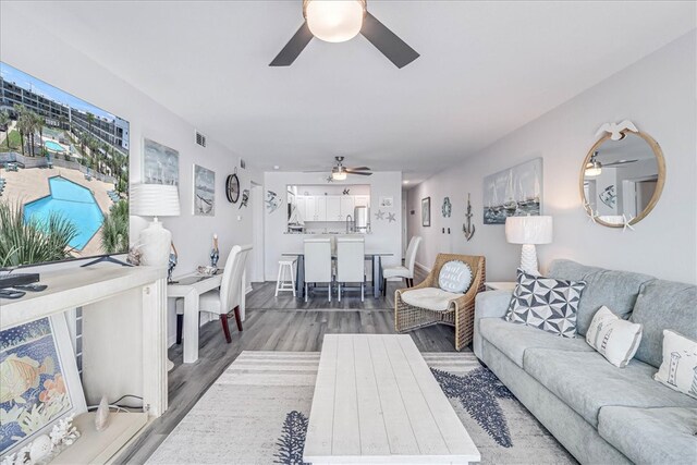 living room featuring dark wood-type flooring and ceiling fan