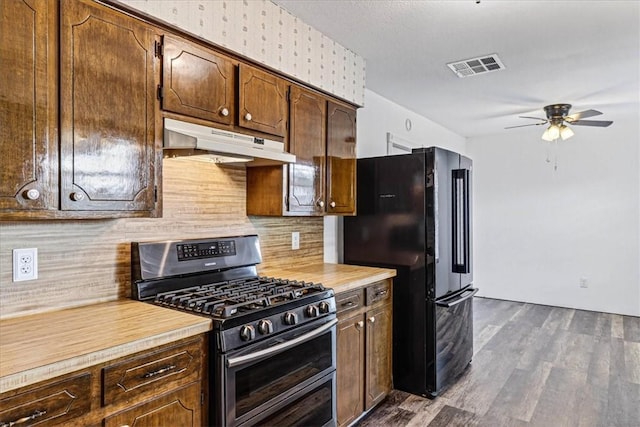 11129 Mulholland Dr, Corpus Christi, TX 78410 - kitchen with stainless steel gas range oven, under cabinet range hood, freestanding refrigerator, ceiling fan, and light countertops