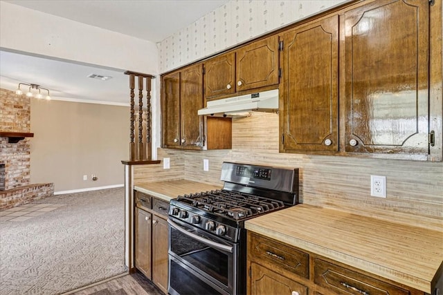 11129 Mulholland Dr, Corpus Christi, TX 78410 - kitchen with stainless steel range with gas cooktop, under cabinet range hood, light countertops, tasteful backsplash, and rail lighting