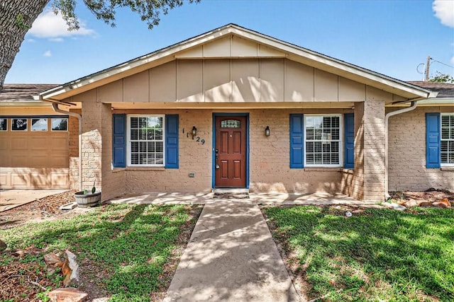 11129 Mulholland Dr, Corpus Christi, TX 78410 - view of front of house featuring an attached garage, board and batten siding, a porch, and brick siding