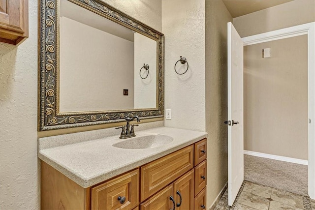 11129 Mulholland Dr, Corpus Christi, TX 78410 - bathroom with a textured wall, vanity, and stone finish floors