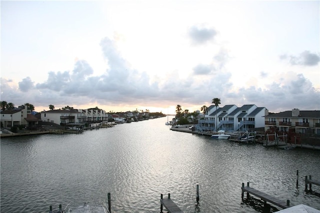 water view featuring nearby suburban area and a boat dock