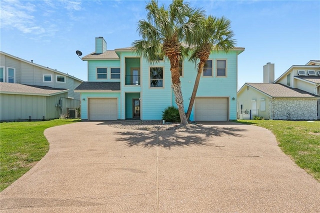 227 Windjammer St, Rockport, TX 78382 - view of front of property featuring an attached garage, driveway, a front yard, and a chimney