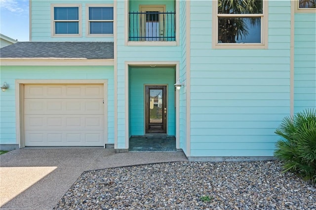 227 Windjammer St, Rockport, TX 78382 - view of exterior entry featuring concrete driveway, a garage, and a shingled roof