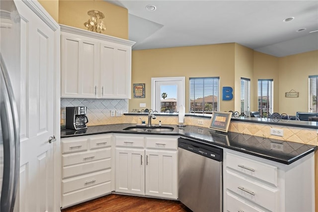 227 Windjammer St, Rockport, TX 78382 - kitchen with stainless steel appliances, a sink, a peninsula, dark countertops, and tasteful backsplash