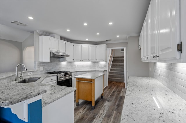 kitchen featuring kitchen peninsula, white cabinetry, sink, and stainless steel gas range