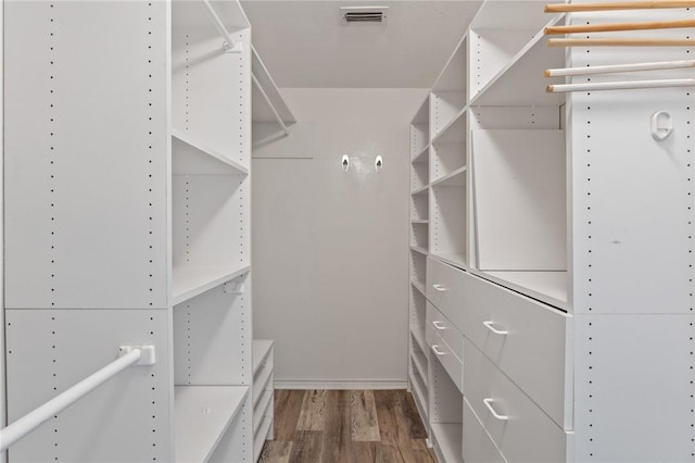 spacious closet with dark hardwood / wood-style flooring