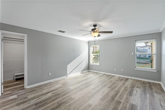 unfurnished bedroom with ceiling fan, light hardwood / wood-style floors, crown molding, and a closet