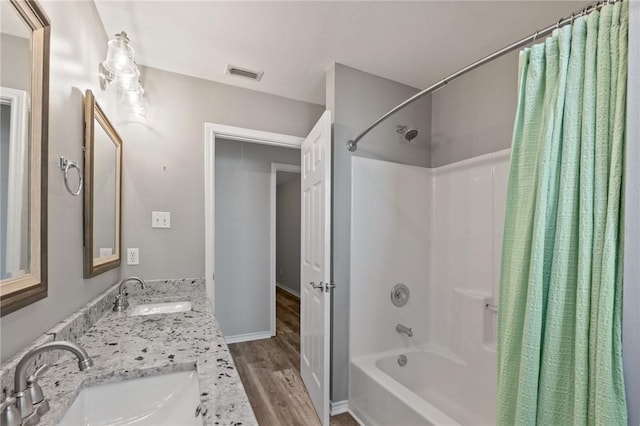 bathroom with wood-type flooring, vanity, and shower / bath combo with shower curtain