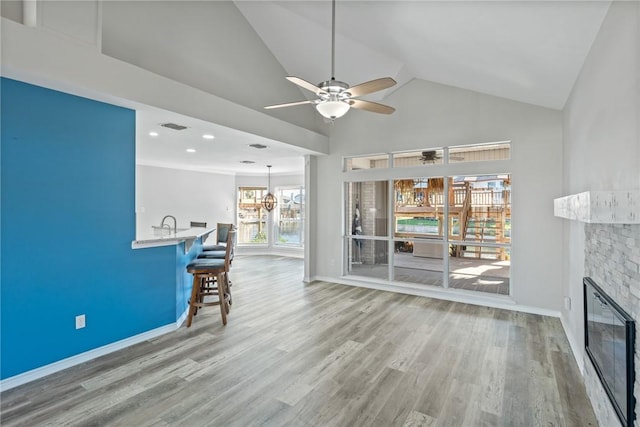 unfurnished living room featuring ceiling fan, lofted ceiling, and hardwood / wood-style flooring