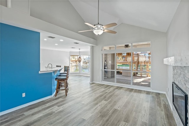 13845 Jolly Roger St, Corpus Christi, TX 78418 - living room with ceiling fan, wood finished floors, baseboards, a fireplace, and high vaulted ceiling