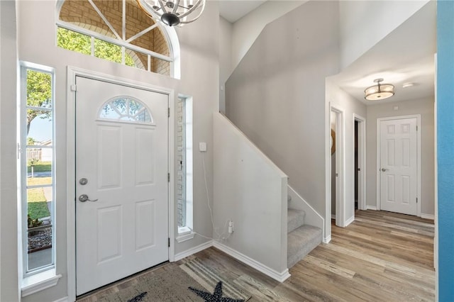 entrance foyer featuring a notable chandelier, a high ceiling, and light hardwood / wood-style flooring