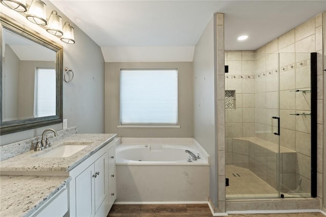 bathroom with hardwood / wood-style floors, vanity, and independent shower and bath