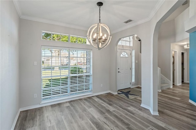 foyer entrance featuring a chandelier, hardwood / wood-style flooring, and crown molding