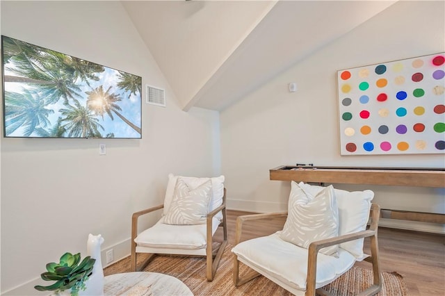 sitting room with hardwood / wood-style floors and vaulted ceiling