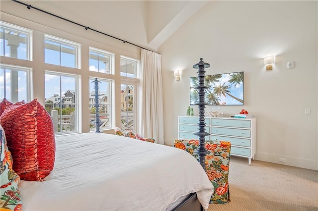 bedroom featuring light carpet and a high ceiling