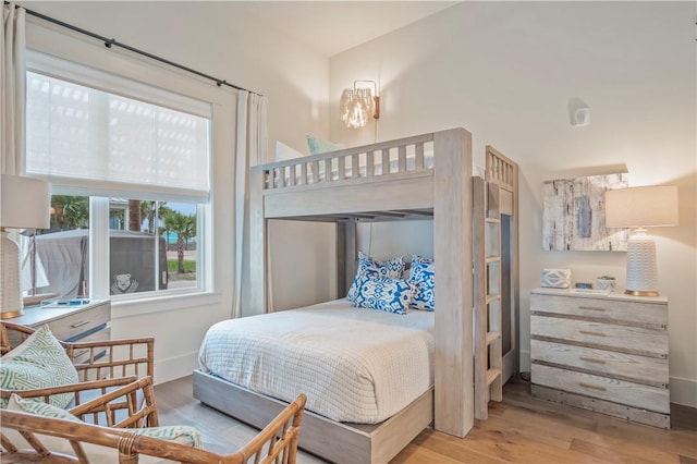 bedroom featuring a high ceiling and light hardwood / wood-style floors