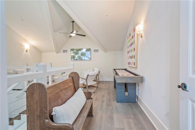 living area with vaulted ceiling, ceiling fan, and light wood-type flooring