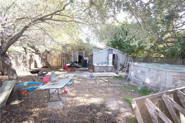 view of yard with a storage shed and a covered pool