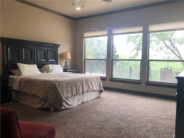 carpeted bedroom featuring multiple windows, ceiling fan, and crown molding