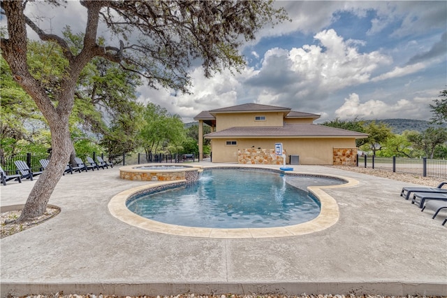 view of swimming pool with a patio and an in ground hot tub