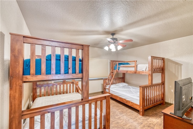 bedroom with hardwood / wood-style flooring, ceiling fan, and a textured ceiling