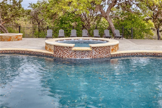 view of pool featuring a patio area, pool water feature, and an in ground hot tub