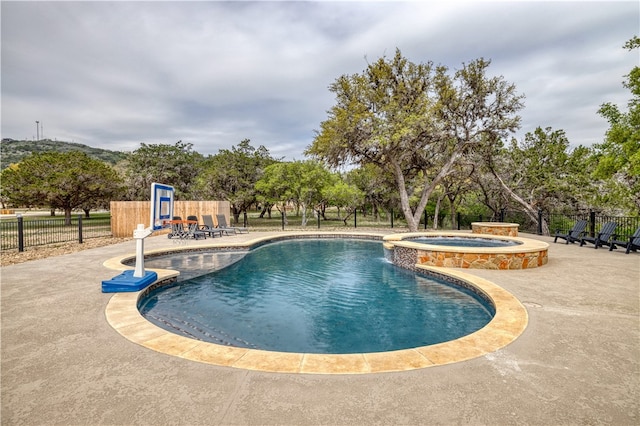 view of swimming pool featuring a patio and an in ground hot tub