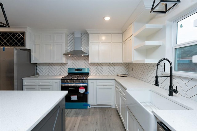 kitchen with white cabinets, wall chimney exhaust hood, and appliances with stainless steel finishes