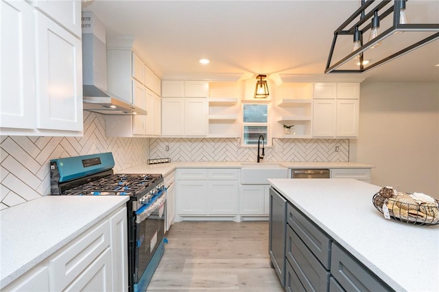 kitchen featuring sink, wall chimney range hood, appliances with stainless steel finishes, gray cabinetry, and white cabinets