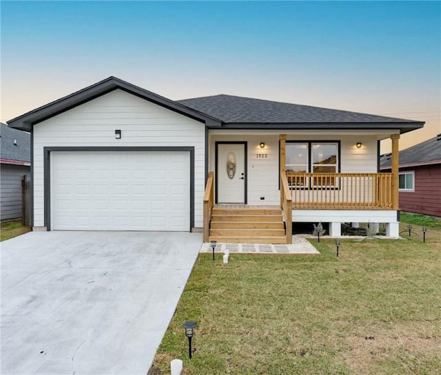 single story home with a garage, a yard, and covered porch